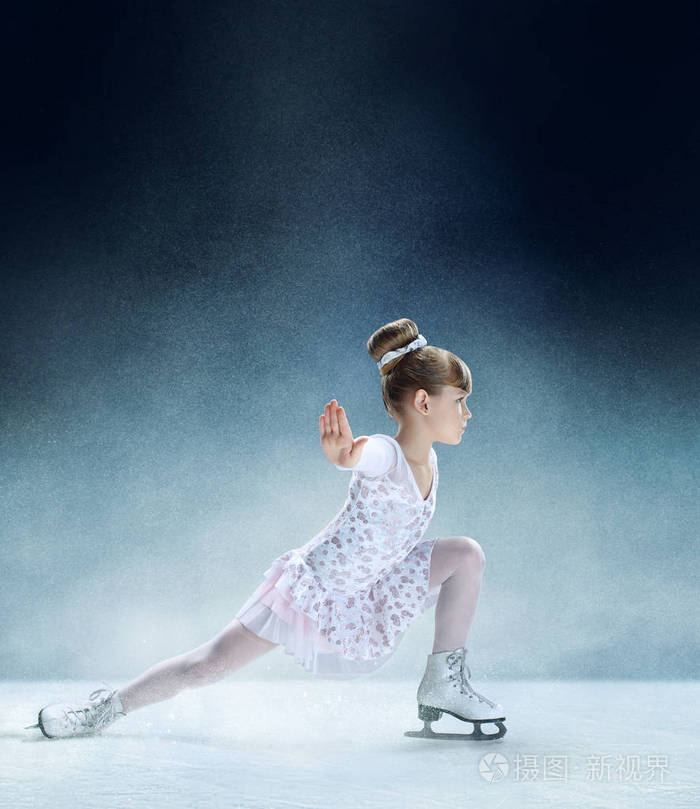 在室内冰上的花样滑冰小女孩