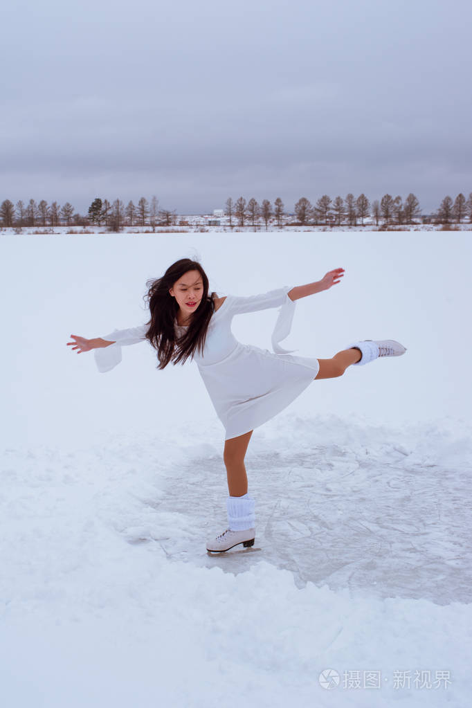 亚洲女孩在户外滑冰冬天穿白色裙子