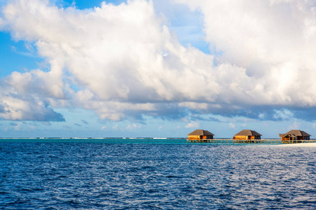 美丽的日落景观在马尔代夫岛上的沙滩上，五彩缤纷的天空和波浪海上的戏剧性云