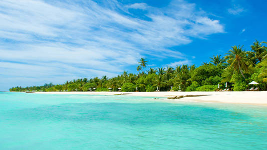 美丽的沙滩，印度洋上有日光浴和雨伞，马尔代夫岛