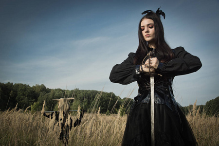 鬼剑哥特式女孩,手里拿着剑,挨着一头牛的头骨,在