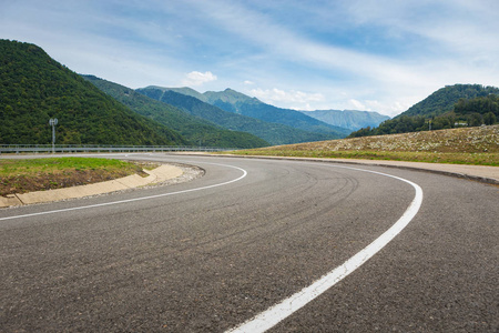 弯曲道路的景色。 在山路上开车。 山上的沥青路。 空路背景