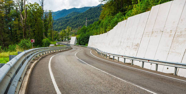 弯曲道路的景色。 在山路上开车。 山上的沥青路。 空路背景