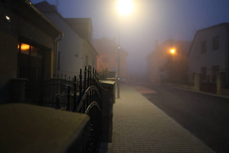 早晨的城市街道在雾中的栅栏细节