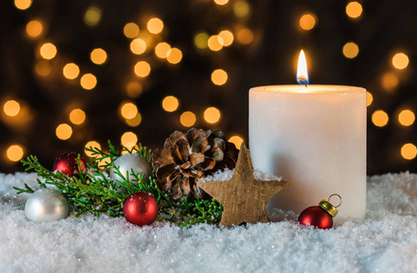 传统的圣诞节时间假日季节蜡烛,装饰和装饰在雪地上,背景模糊照片