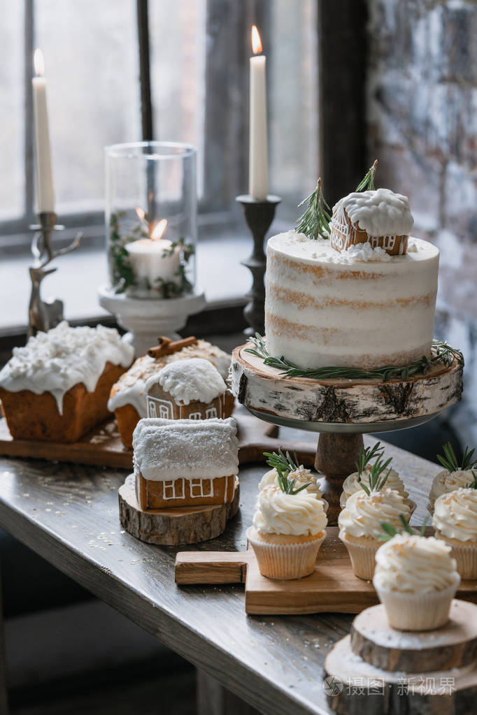 圣诞节装饰的甜点桌上有各种糕点,姜饼,家庭蛋糕和蜡烛