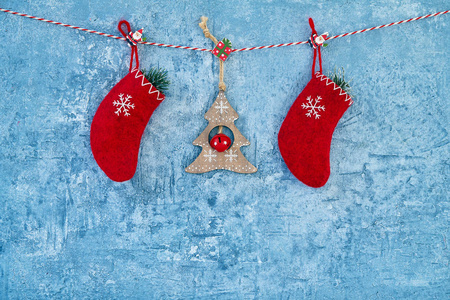 圣诞背景。 红色圣诞装饰挂在蓝色背景上的绳子上。 复制空间。