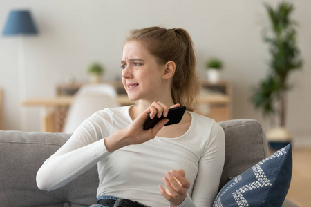不安的女孩扔智能手机得到坏消息照片