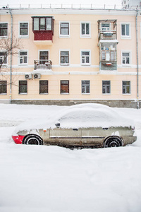 在停车场的冬季暴风雪中，车辆被雪覆盖。白雪覆盖的道路和城市的街道。