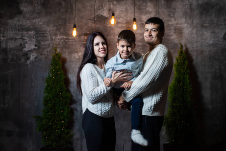 s portrait of a happy family near Christmas trees, walls and bri