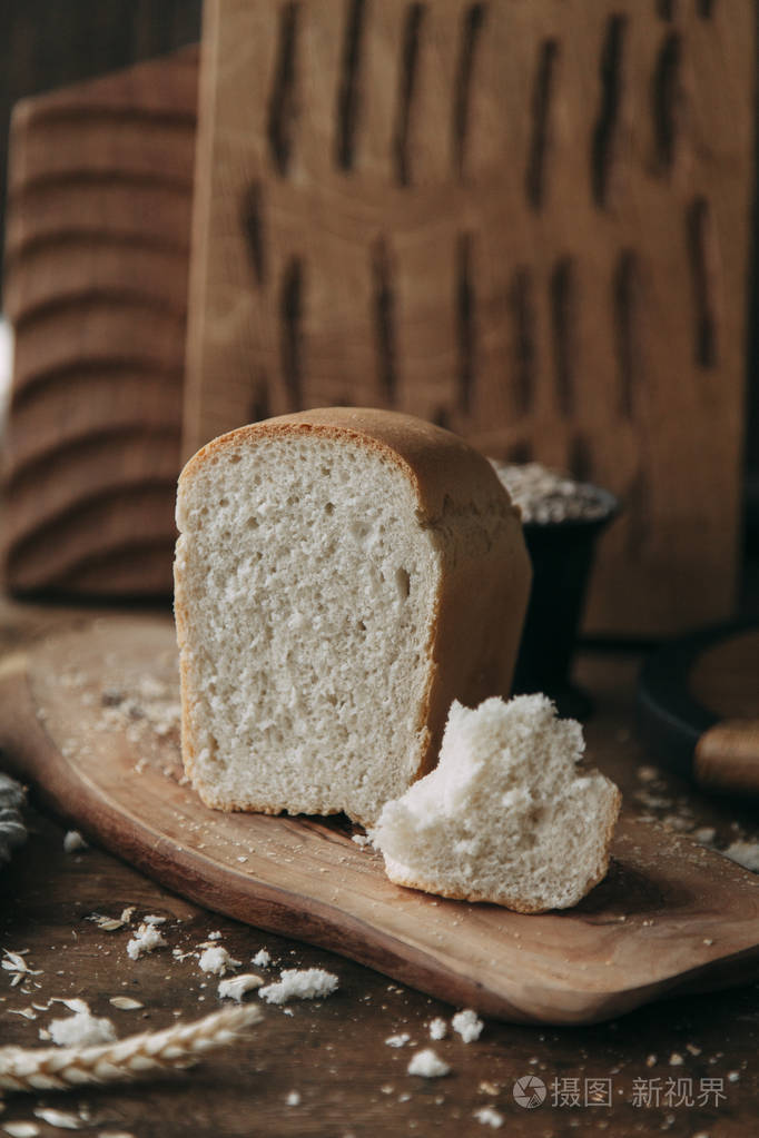黑色木制背景上的新鲜黑麦和谷物面包.食品造型和烹饪与新鲜配料.