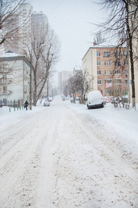 在停车场的冬季暴风雪中，车辆被雪覆盖。白雪覆盖的道路和城市的街道。