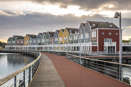 荷兰现代五颜六色的藤蔓建筑风格的房子在水边戏剧性和云彩日落。 乌滕乌特勒支。