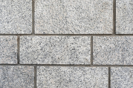灰色花岗岩长方形砖墙的背景纹理,在完整的框架视图中均匀灌浆.照片