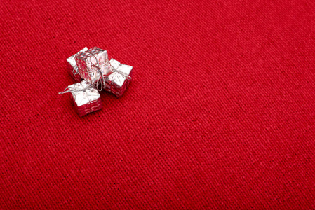 美丽的小银礼品盒在红色针织面料背景
