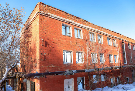 在冬天的一天，旧的废弃和毁坏的建筑从红砖砌成的蓝天