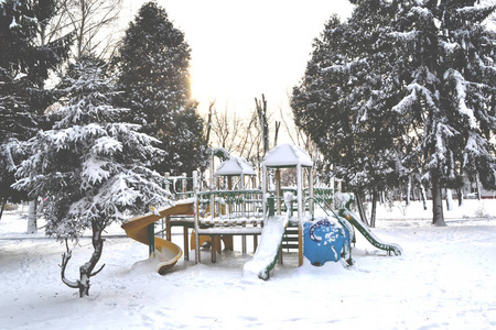 冬季游乐场的孩子们。 公园里的雪。 被雪覆盖的树。