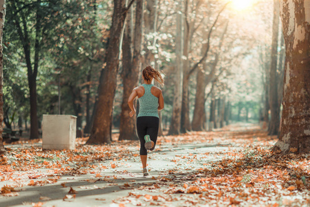 秋天在公共公园户外慢跑的女人