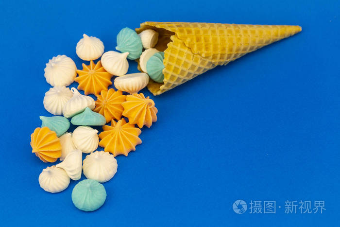 华夫饼里的甜棉花糖洒在蓝色的背景上冰淇淋形式的蛋奶酥