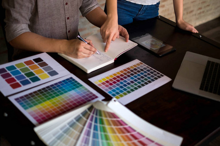 平面设计师从色带样品中选择颜色进行设计。设计师平面创意工作理念..