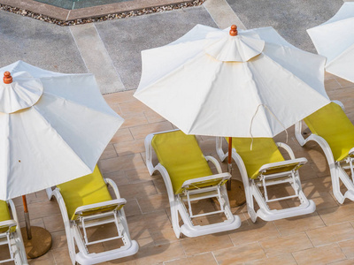 酒店和度假胜地豪华室外游泳池周围的雨伞和椅子，供您度假和旅行