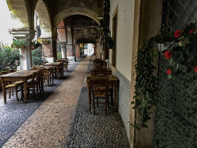 通过意大利维罗纳的Sottoriva历史中心。 古城的街道之一。 街上餐馆和酒馆使用的桌子的细节