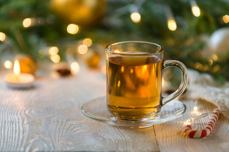 圣诞节热茶在一个玻璃透明杯与茶圣诞树和糖果。