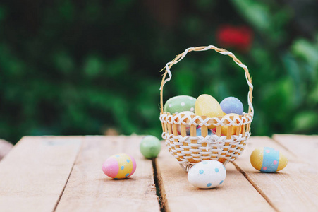 五颜六色的复活节彩蛋在木桌上的篮子里赢得复制空间。