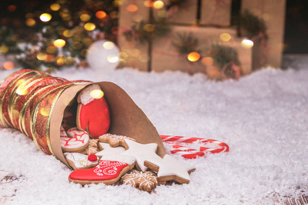 圣诞姜饼和圣诞装饰品在木制背景与雪。 复制空间。