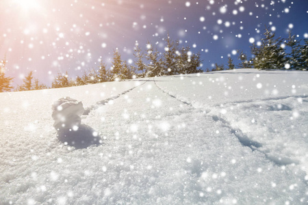 美丽的冬季圣诞景观。 陡峭的山坡上，有着人类的小径，在晶莹的深雪和绿色的云杉树上，五颜六色的大雪花在清澈的蓝天上复制着空间背景。
