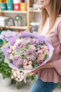 欧洲花卉店。美丽的混合花的花束在女人的手。优秀的园林花卉在布置上, 工作上有专业的花店