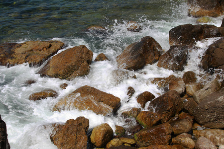 美丽的海浪在岩石海岸的岩石上破碎。明亮的景观视野作为夏季旅游广告的背景，在海上海洋上休息。海浪冲击岩石的海景