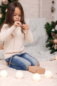 可爱的女孩包装圣诞礼物在家里