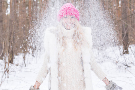 愉快的年轻妇女玩雪在雪地森林户外