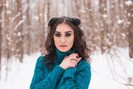 在冬天行走的快乐年轻女子的肖像。美丽的女孩在雪的自然