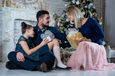 圣诞照片的幸福家庭与礼品盒背景装饰圣诞树。 家人庆祝新年