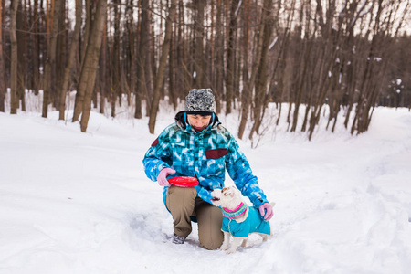 宠物主人和冬季概念中年妇女在雪园里和她的杰克罗素犬狗玩耍