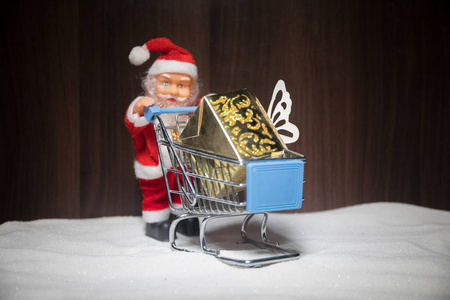 新年或圣诞节假日购物概念。 商店促销。 圣诞老人扛着手推车上雪