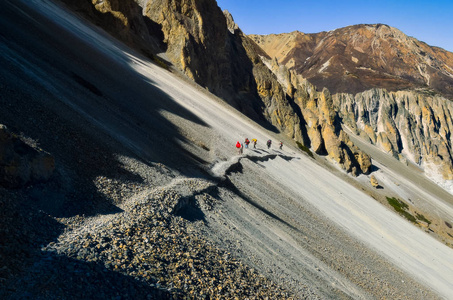 一群登山徒步旅行者在喜马拉雅山安纳普尔纳地区的一座陡峭的岩石山上行走，尼泊尔亚洲