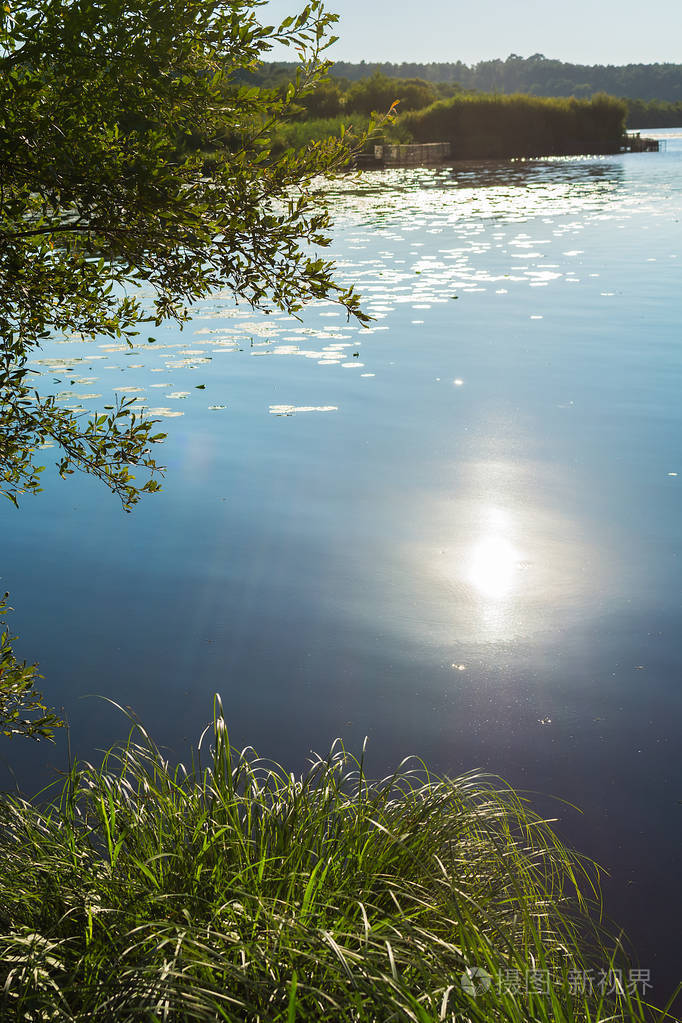 日落时美丽的湖泊景观.太阳反射在水中