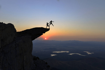 成功的登山者展示了力量和不寻常的悬崖照片