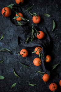 成熟的柑橘的顶部视图与叶子在纹理黑暗的背景