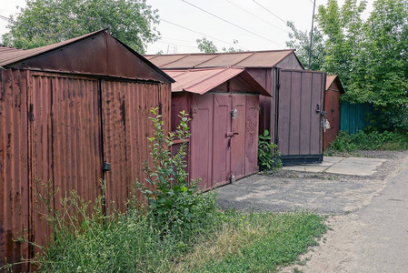 旧的棕色铁车库在附近的草丛中图片
