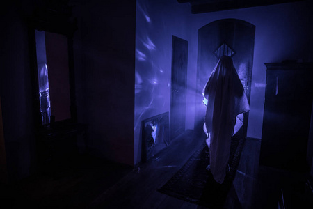 黑暗里的光带镜子的黑暗房间里鬼的恐怖轮廓. 可怕的万圣节概念.