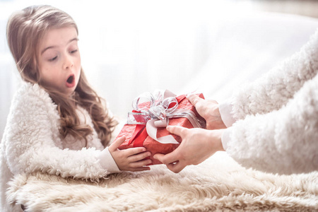 圣诞节和新年概念妈妈送给一个小可爱的女儿一个地方，在浅色背景下发短信