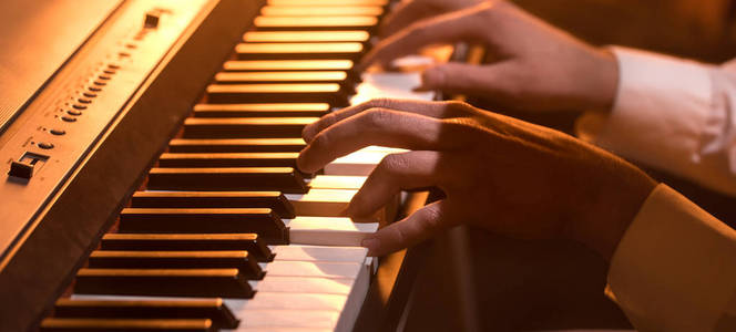 男手在钢琴琴键上特写一个美丽多彩的背景音乐活动的概念