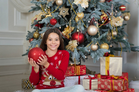 圣诞节。准备好了吗。孩子享受假期。新年快乐。圣诞节前的第二天早上新年假期。小快乐的女孩在圣诞节。小女孩喜欢圣诞礼物。红球