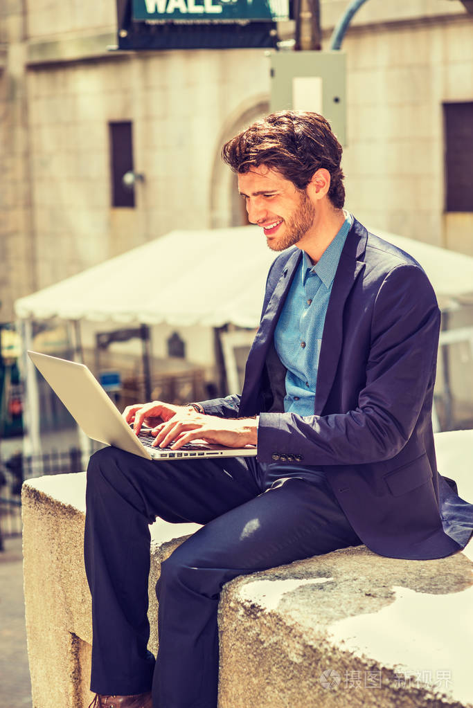欧洲商人在纽约工作穿着蓝色西装一个留着胡子的年轻人坐在街上微笑着