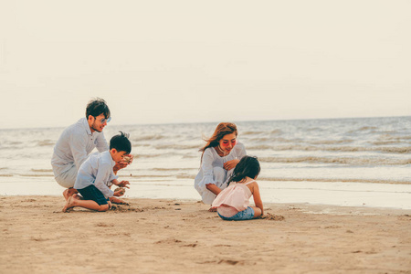 爸爸,妈妈和孩子们的幸福家庭在夏天去热带沙滩度假.照片
