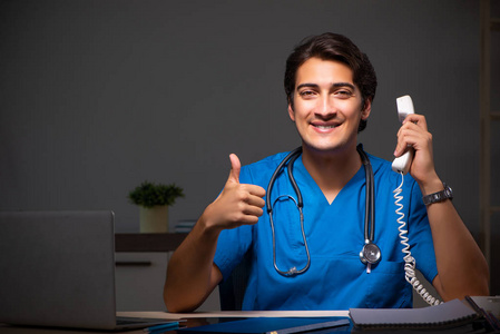 年轻英俊医生夜班在医院照片